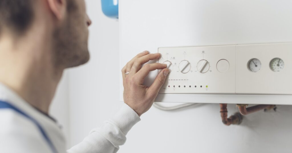 Professional plumber checking a boiler control panel